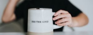 Person holding a mug that says 'see the good'